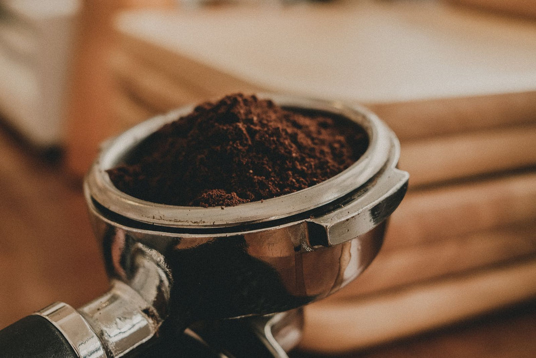 An espresso portafilter filled with freshly ground coffee